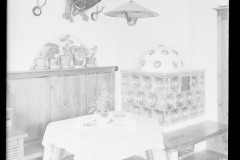 Stube/ Speisezimmer Café - Hubertus Bach von innen, mit Tiergeweihen an den Wänden, Ofen, viel Deko und mit Blumen geschmückten Tischen