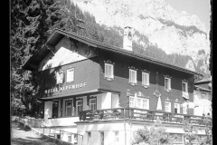 Hotel Alpenhof am Haldensee, mit Terasse und Wald, dahinter felsige Berge