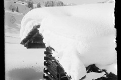 Holzhütte, dick verschneit in einer Schneelandschaft