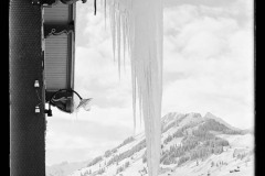 Eiszapfen hängen von einer Regenrinne, blick auf Hirschegg Zentrum