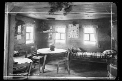 Stube Riezleralpe mit Esstisch, Stühlen und Bett, sowie Fenster und Dekoration