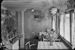 Speisesaal mit vielen Pflanzen sowie Stühle und Tische mit Tischdecken