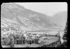 Ortschaft mit Zentrum und Kirche von Wald und Bergen umgeben