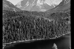 Zugspitze und Fernsteinsee umgeben von Wald und felsigen Berggipfeln