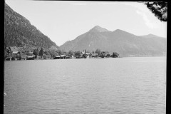 See mit Ufer umgeben von hohen, bewaldeten Bergen.