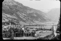 Ortschaft mit Zentrum und Kirche von Wald und Bergen umgeben