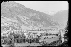 Ortschaft mit Zentrum und Kirche von Wald und Bergen umgeben