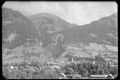 Ortschaft mit Zentrum, Wohnhäusern und Kirche von Wald und Bergen umgeben