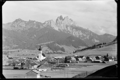 Ortszentrum Tannheim mit Kirche und Wohnhäusern, umgeben von Bergen und Wald