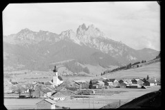 Ortszentrum Tannheim mit Kirche und Wohnhäusern, umgeben von Bergen und Wald
