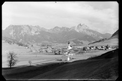 Ortszentrum Tannheim mit Kirche und Wohnhäusern, umgeben von Bergen und Wald