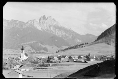 Ortszentrum Tannheim mit Kirche und Wohnhäusern, umgeben von Bergen und Wald
