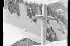 Holzkreuz und verschneite Holzhütte vor dem ifenplateau