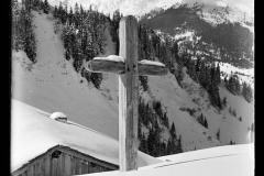 Holzkreuz und verschneite Holzhütte vor dem ifenplateau