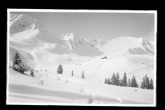 Dick verschneite Schneelandschaft, Fuß/-Skispuren mit Holzhütte und Berggipfeln