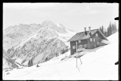 Dick verschneite Schneelandschaft mit Wohnhaus und Blick auf Berge des Kleinwalsertals