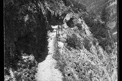 Wanderweg mit steilem, steinigen Abgrund, durch den Wald und Berge