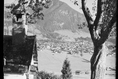 Blick auf das Zentrum mit Kirche in Oberstdorf und dicht bebauten Flächen aus Häusern, eingekesselt von dem Wald und die Berge Oberstdorfs