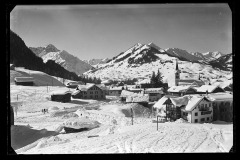 Ortskern Riezlern mit Wohnhäusern, Kirche und Blick auf Hirschegg