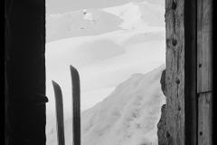 Blick aus einer Holzhütte auf hölzerne Skier