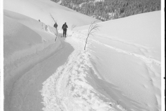 Zwei Skitourengänger durchwandern eine Schneelandschaft in Richtung Ifen