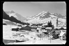 Ortskern Riezlern mit Wohnhäusern, Kirche und Blick auf Hirschegg