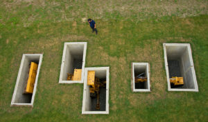 SONY DSC David Brooks, A Proverbial Machine in the Garden, 2013, A buried Dynahoe tractor, concrete, earth, landscape, steel grating